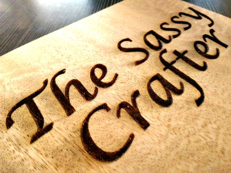 The Sassy Crafter logo engraved in wood